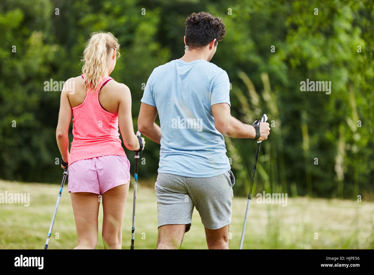 Young couple hiking with persistence while nordic walking Stock Photo