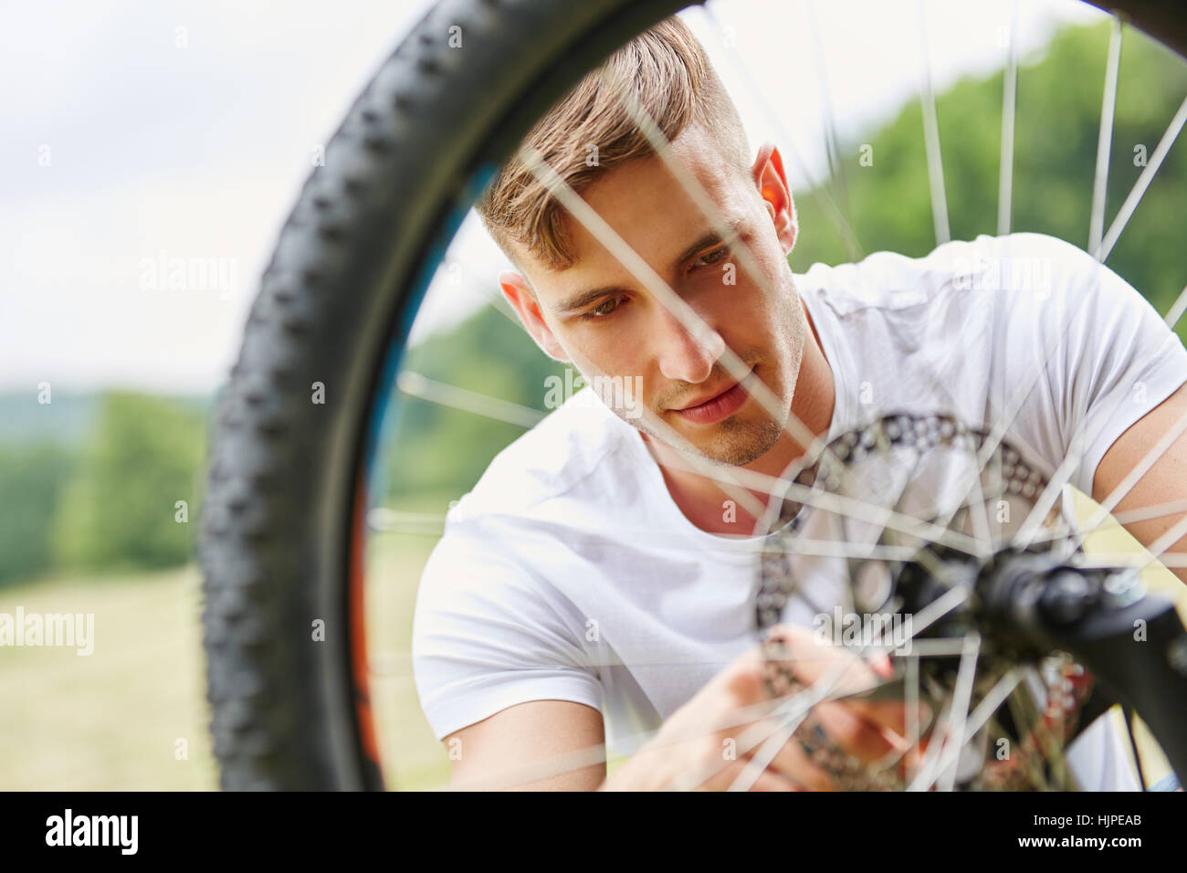 Young man repairs bike after breakdown Stock Photo