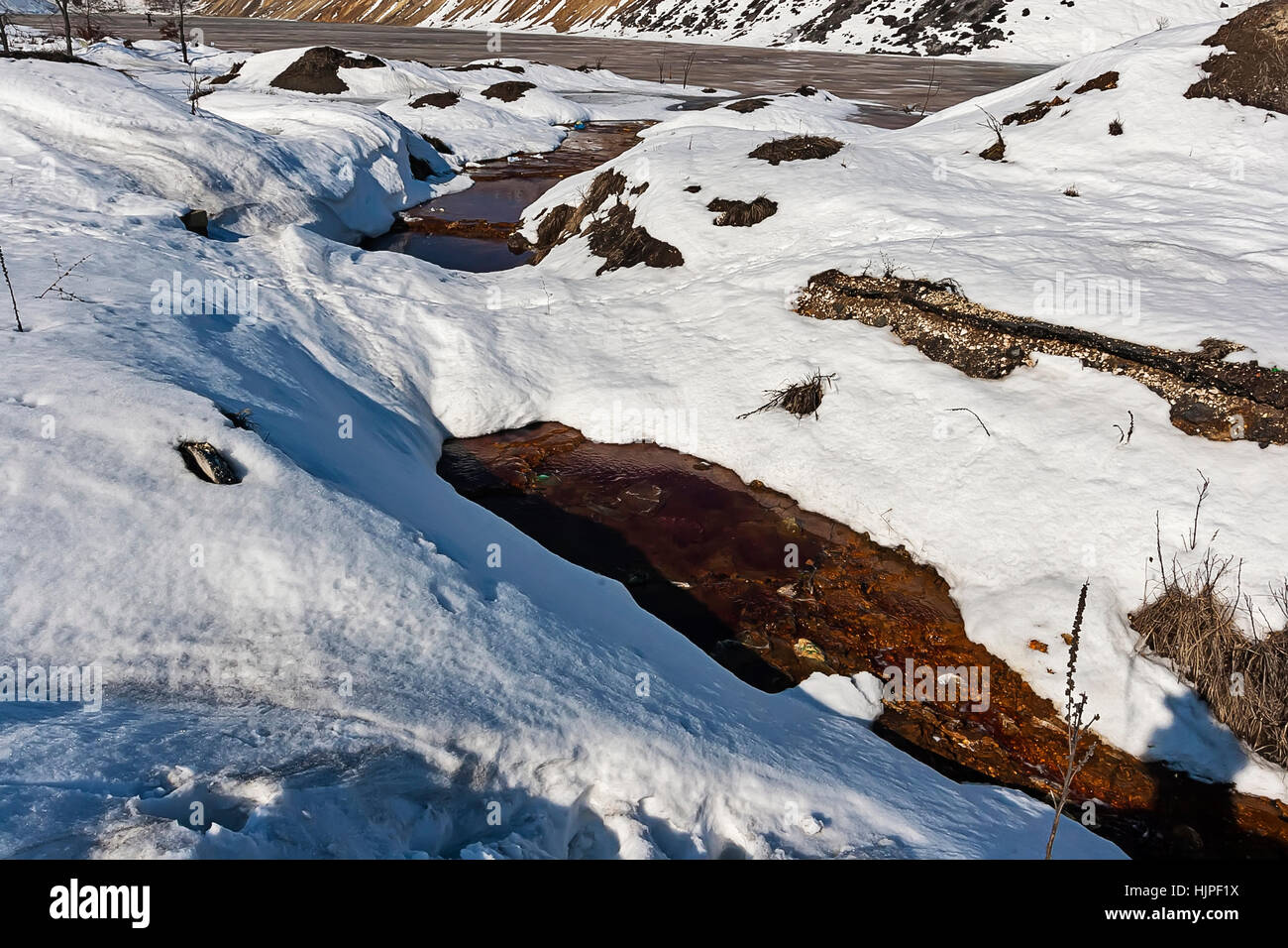 Red poluted river under snow Stock Photo