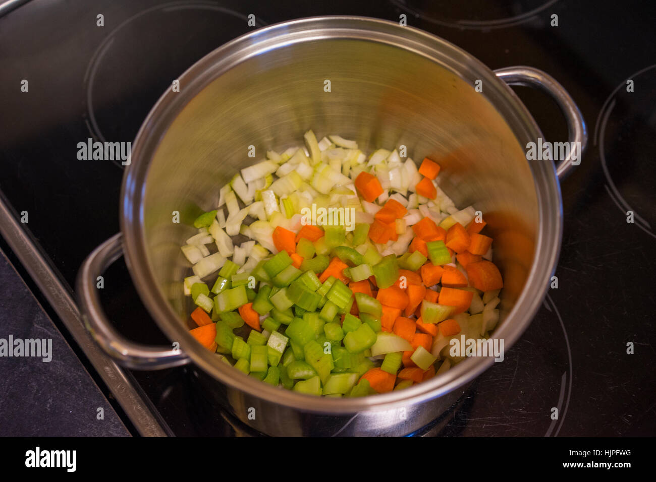 Chopped vegetables in a stock pot. Cooking veg on a stove in a kitchen