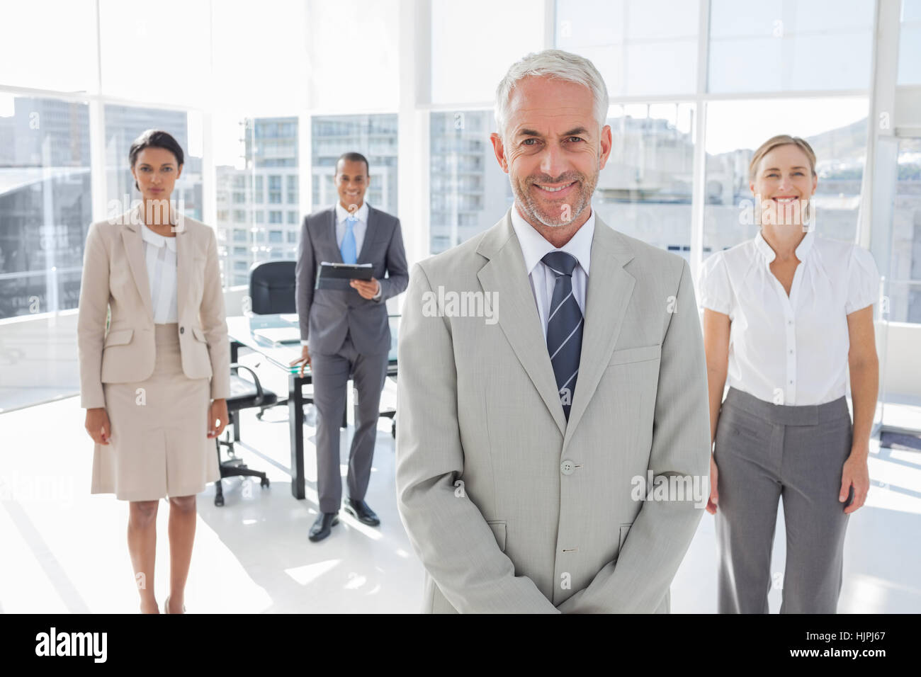 Serious businessman standing with colleagues behind him Stock Photo - Alamy