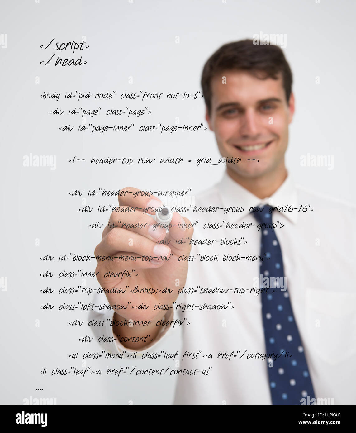 Smiling businessman writing in sql language on a transparent board ...