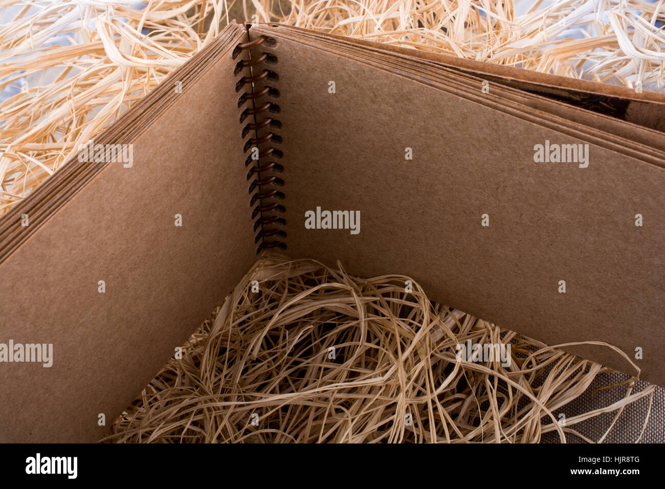 Spiral notebook placed on a straw background Stock Photo - Alamy