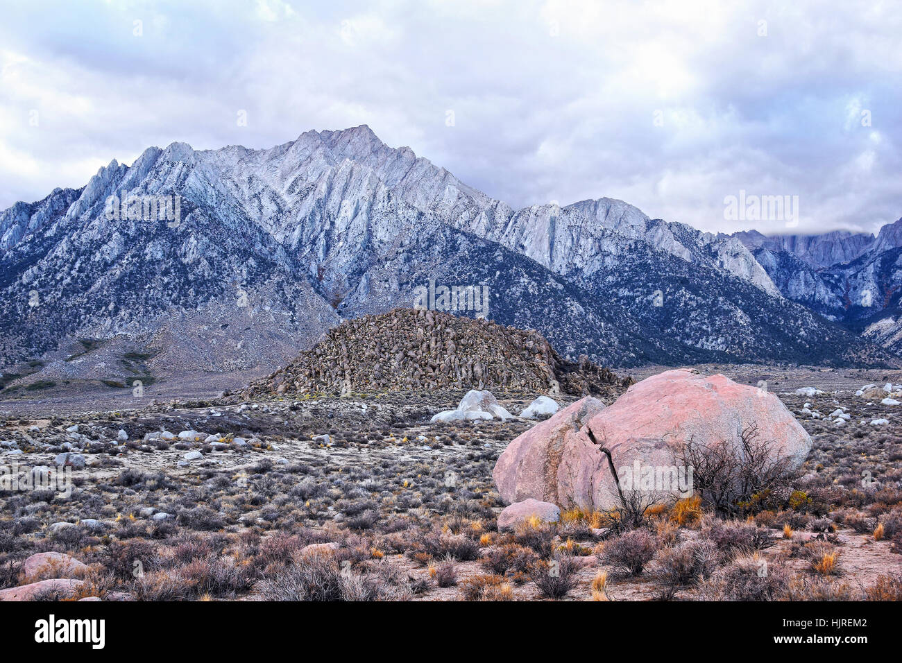 Sierra Nevada Mountains at Alabama Hills, close to the town of Lone Pine, California, USA. Rocks in foreground covered with red micro organisms. Stock Photo