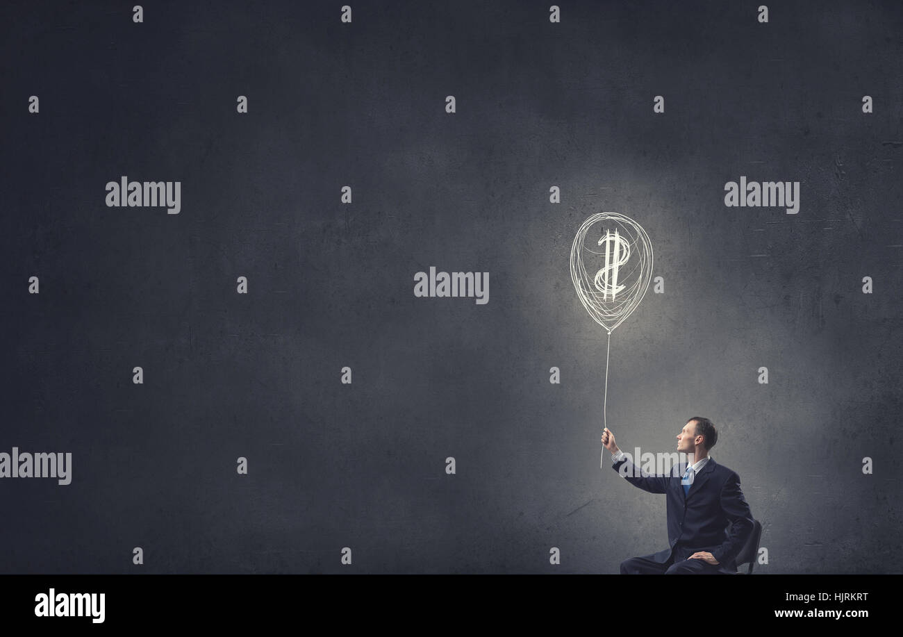 Businessman in chair holding dollar sign balloon hi-res stock ...