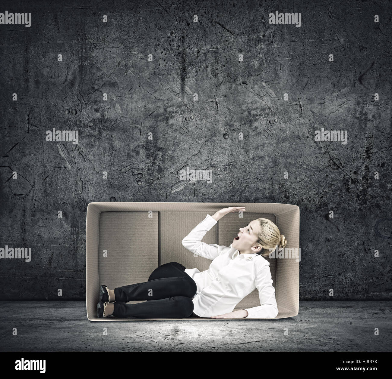 Young emotional woman trapped in carton box Stock Photo - Alamy