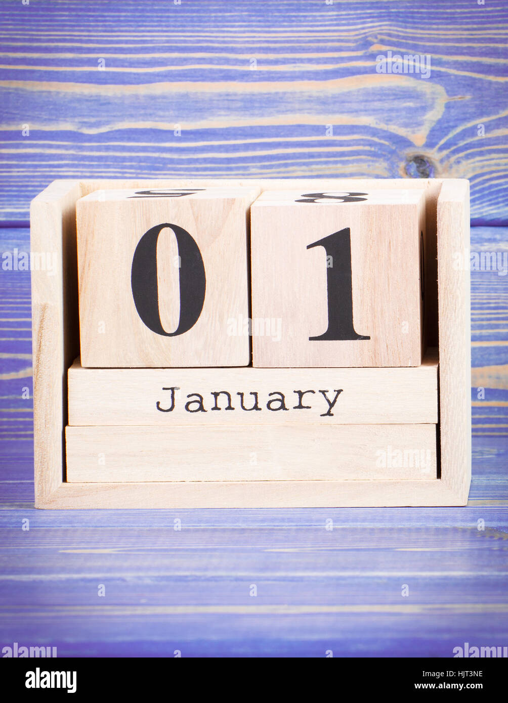 January 1st. Date of 1 January on wooden cube calendar, purple board as