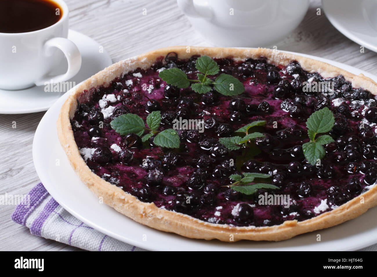 blueberry pie with mint and black coffee on a wooden table horizontal closeup Stock Photo