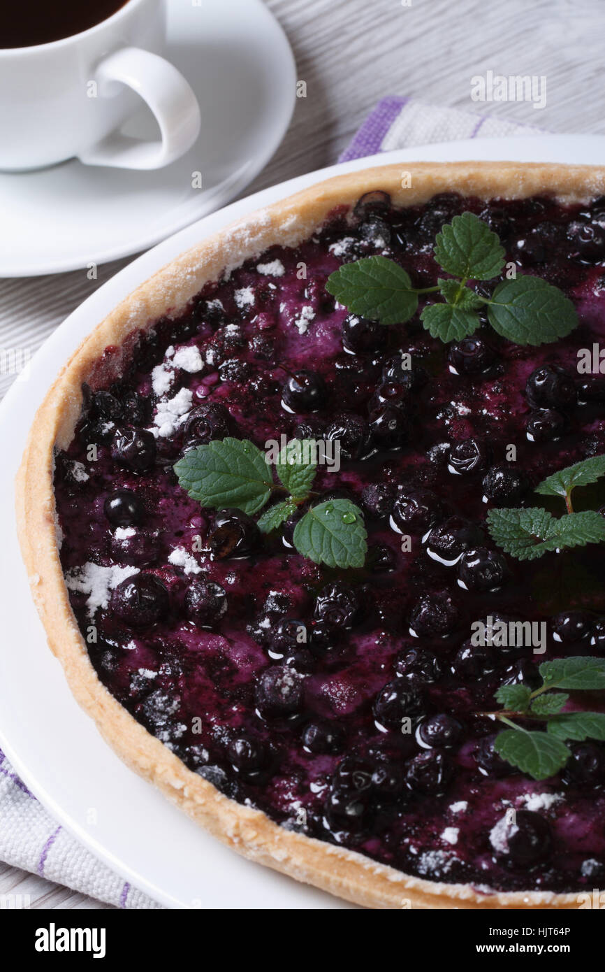 blueberry pie with mint and black coffee on a wooden table vertical closeup Stock Photo