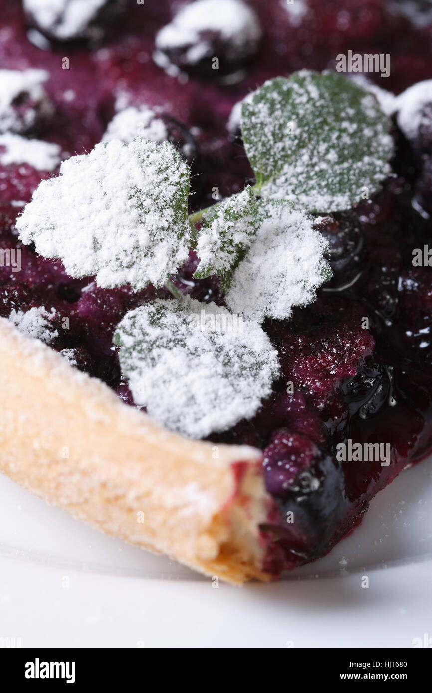 a piece of blueberry pie with mint and powdered sugar on a plate vertical closeup Stock Photo