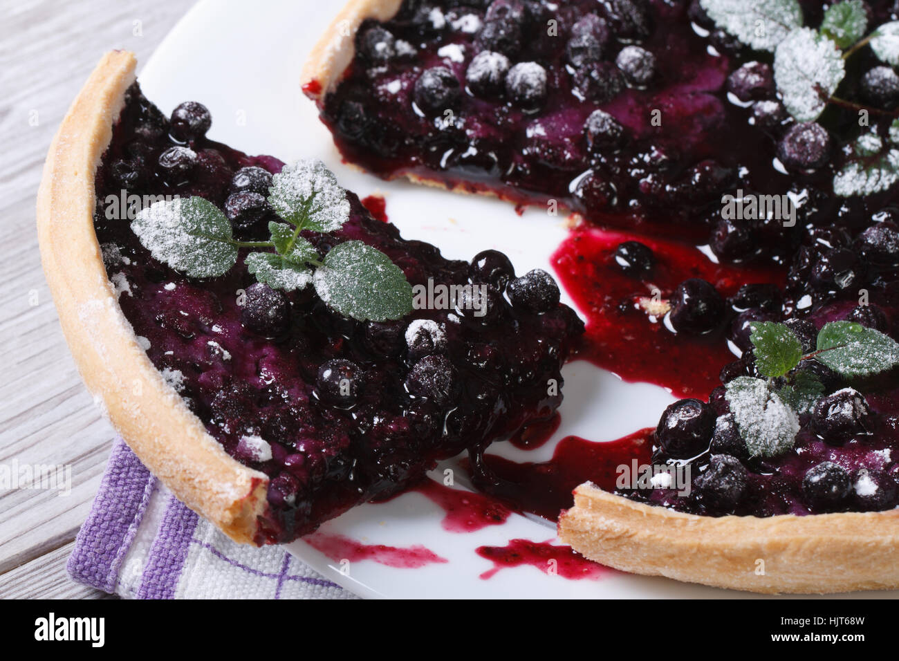cutting blueberry pie with mint and powdered sugar on a plate horizontal closeup Stock Photo