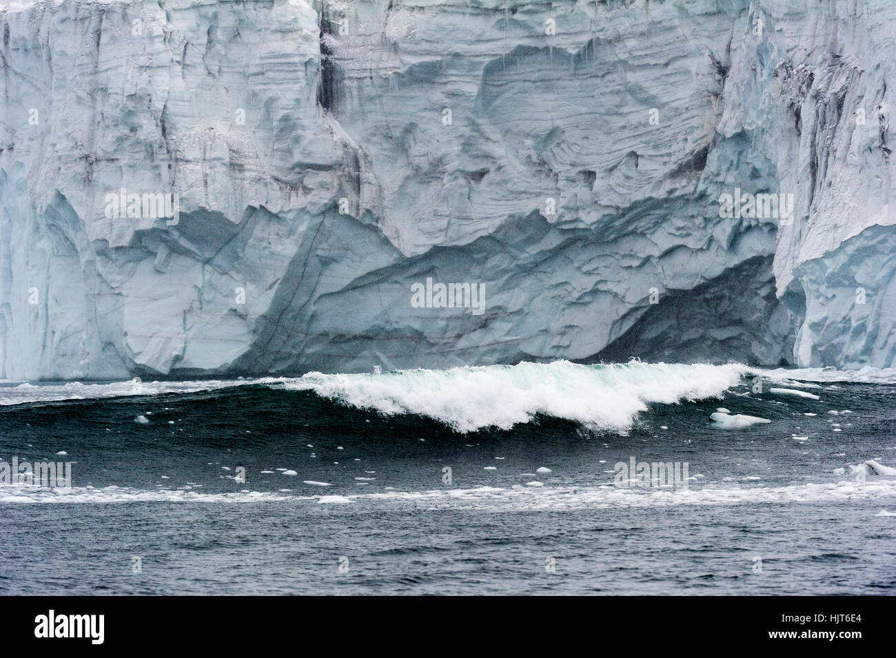 Ice falling from a glacier into the ocean creates huge waves. Stock Photo