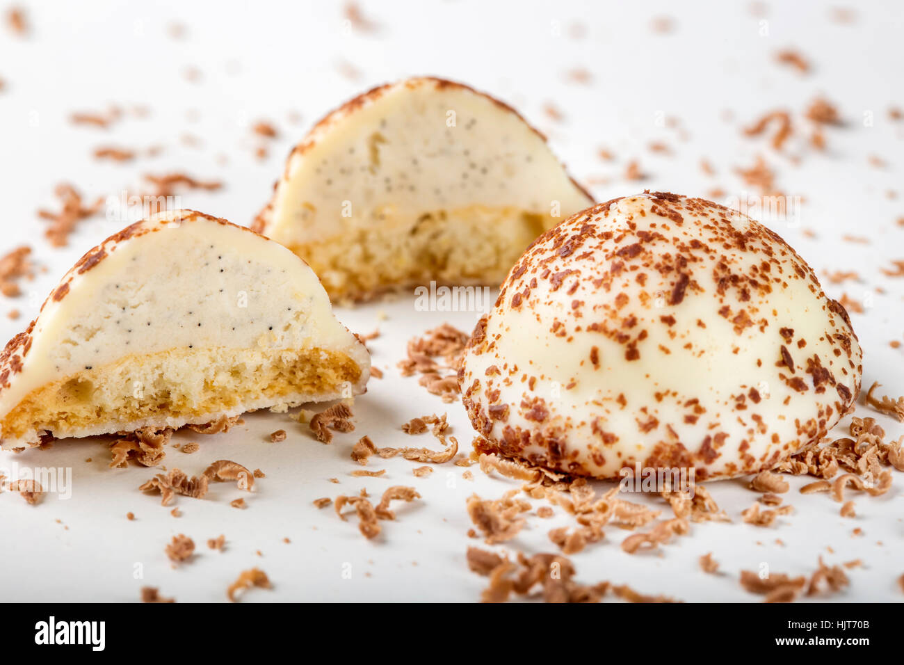 Two vanilla pearl candy, one cut in half, and grated dark chocolate on