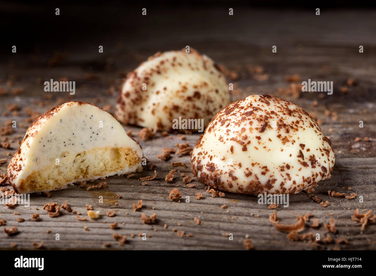 Two vanilla pearl candy, one cut in half, and grated dark chocolate on
