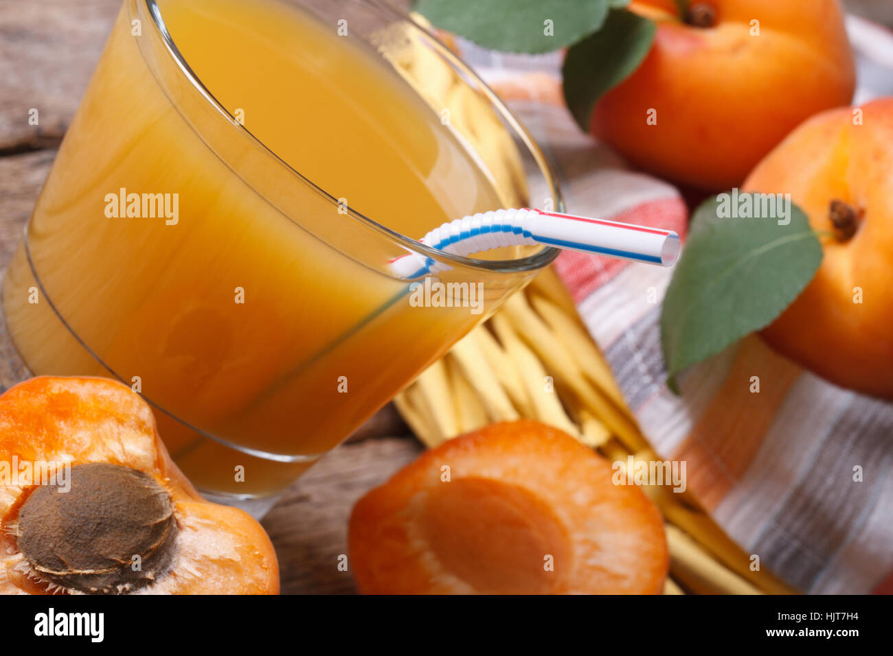 Apricot juice with fruit halves closeup on background basket with fresh