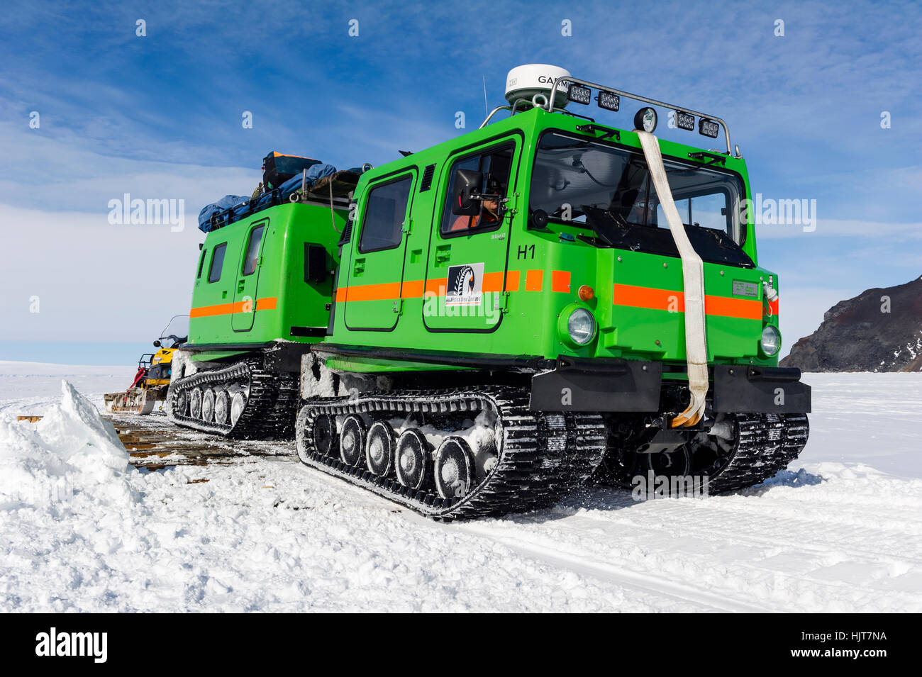 A Hagglund ice vehicle travels over a bridge on sea ice during the Antarctic summer. Stock Photo