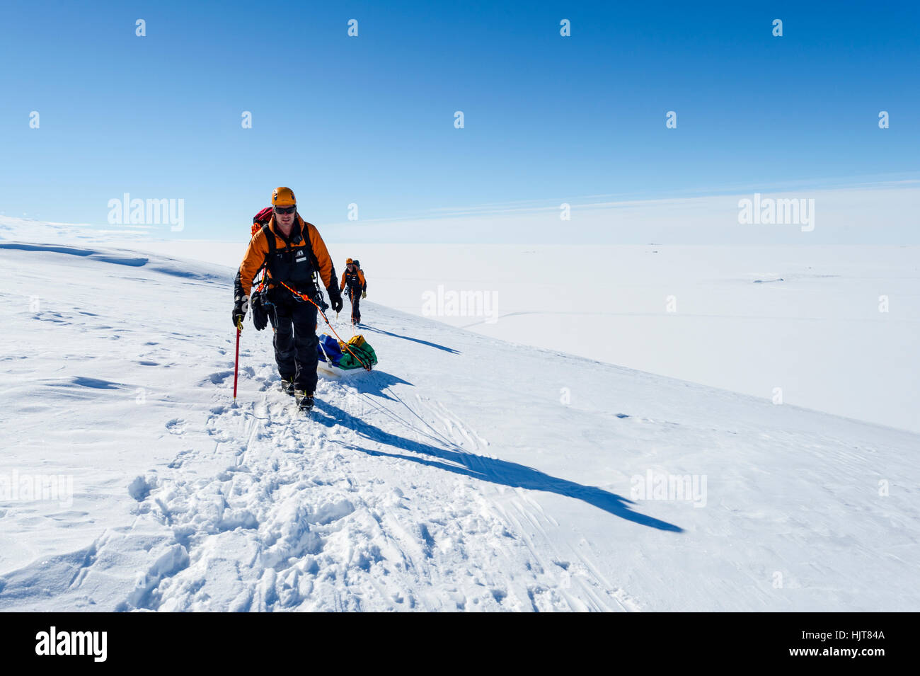Guides hiking across a crevasse field on the slopes of Mount Erebus in Antarctica. Stock Photo