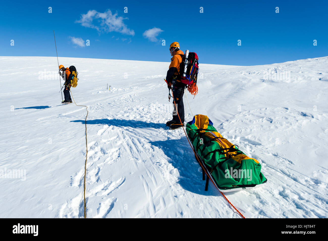 Ice guides hauling a sled as they hike across a crevasse field on the slopes of Mount Erebus in Antarctica. Stock Photo