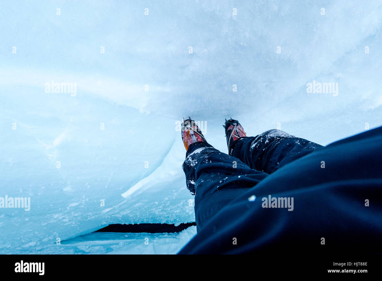 A photographer descending the sheer icy walls of a crevasse on the slopes of Mount Erebus in Antarctica. Stock Photo