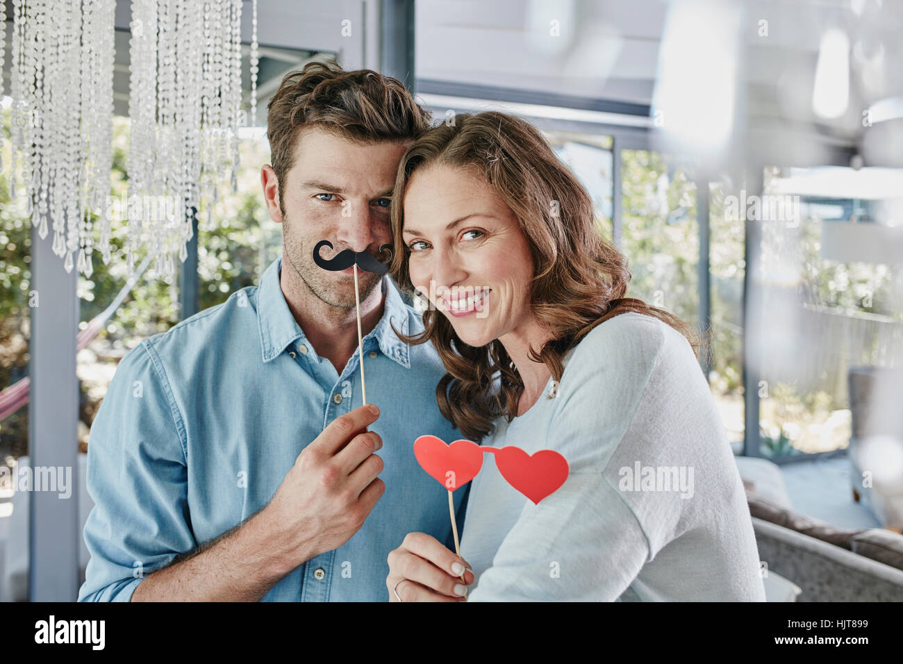 Couple with paper moustache and heart-shaped eye disguise Stock Photo