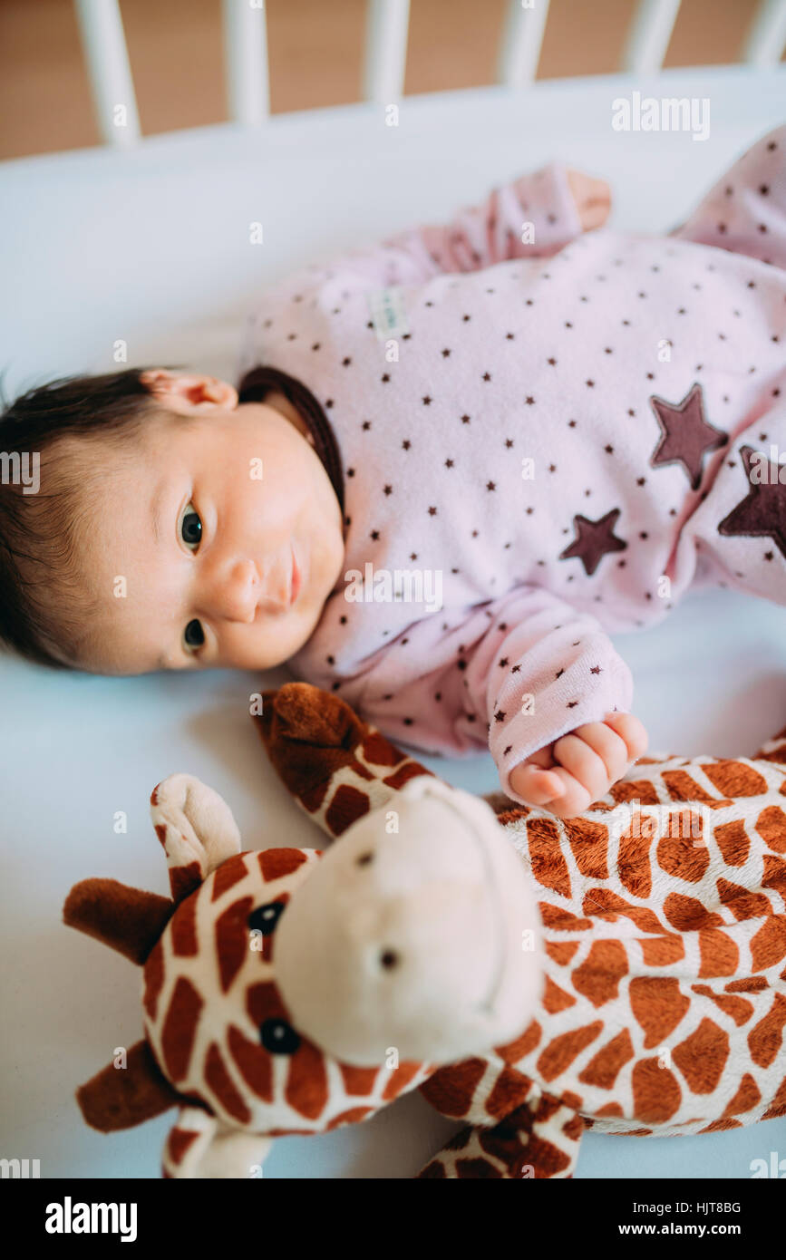 Newborn Baby Girl Lying In Crib With A Plush Giraffe Stock Photo Alamy