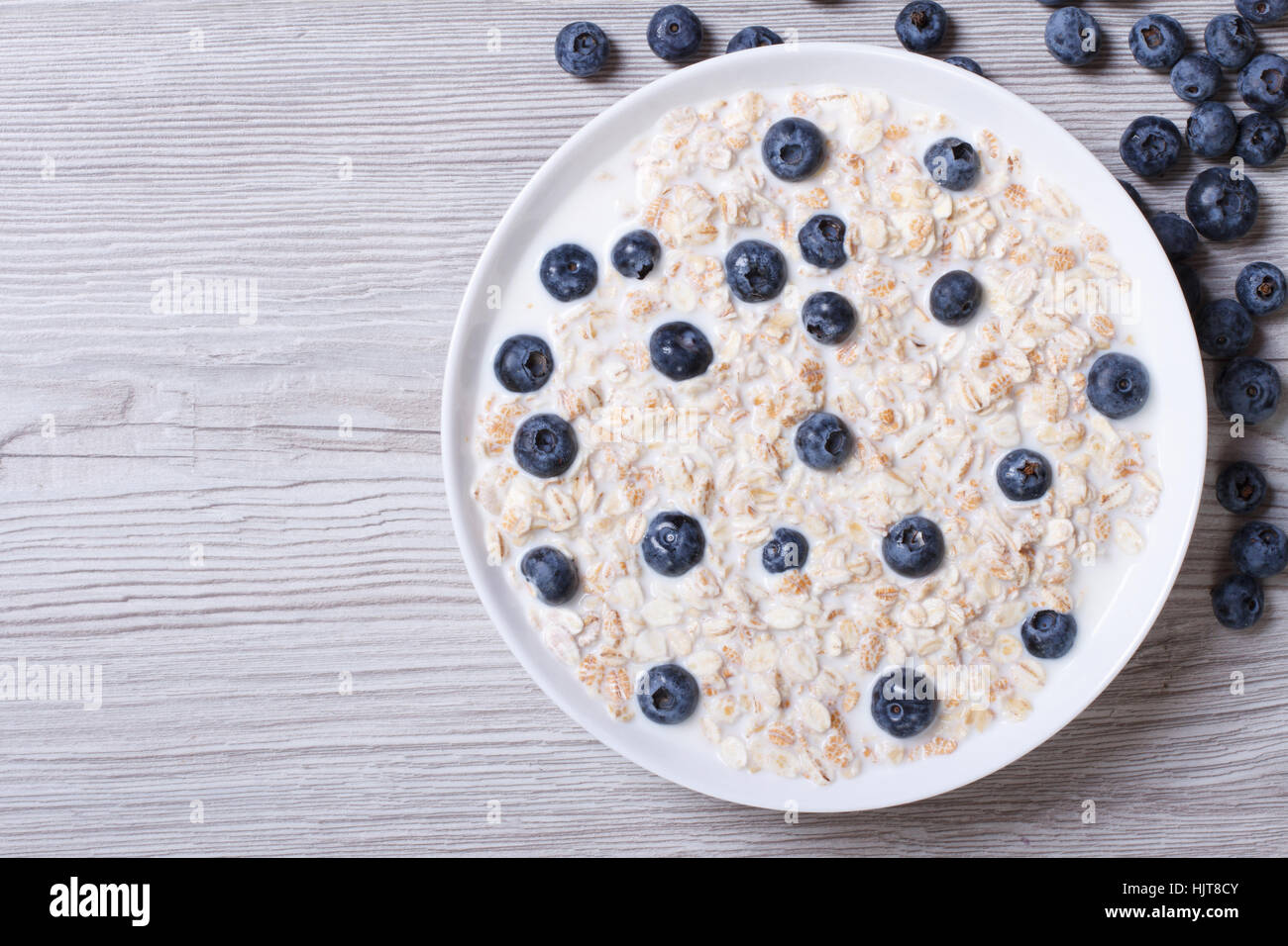 Tasty breakfast of muesli with blueberries and milk closeup on wooden background. top view horizontal Stock Photo