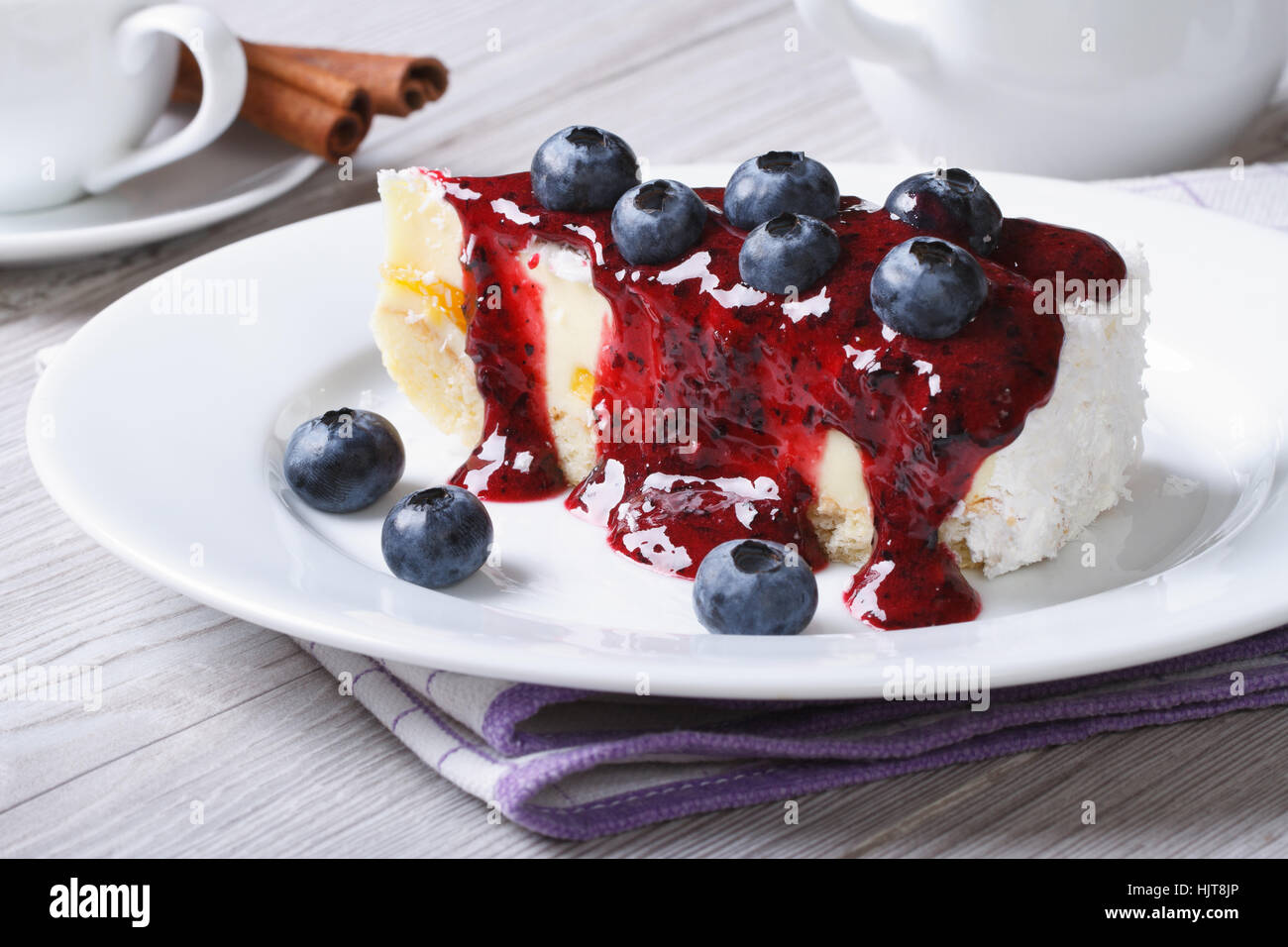 Cake with blueberry, berry sauce on a white plate and coffee on the table horizontal Stock Photo