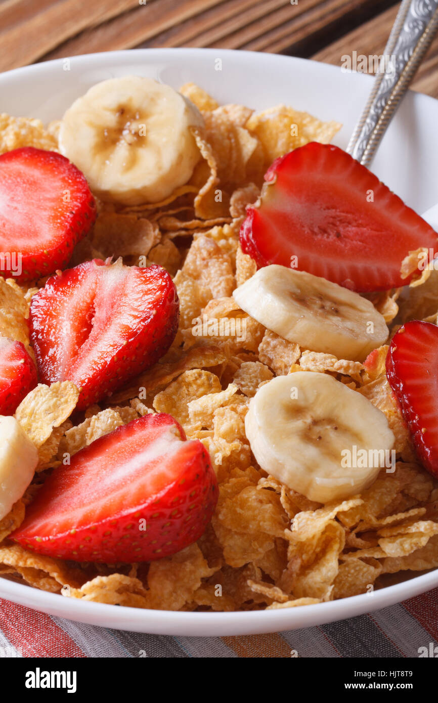 Breakfast muesli with fresh strawberries and banana closeup on table vertical Stock Photo