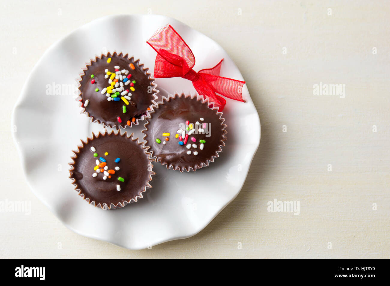 chocolate candies with colorful sprinkles on a white plate Stock Photo