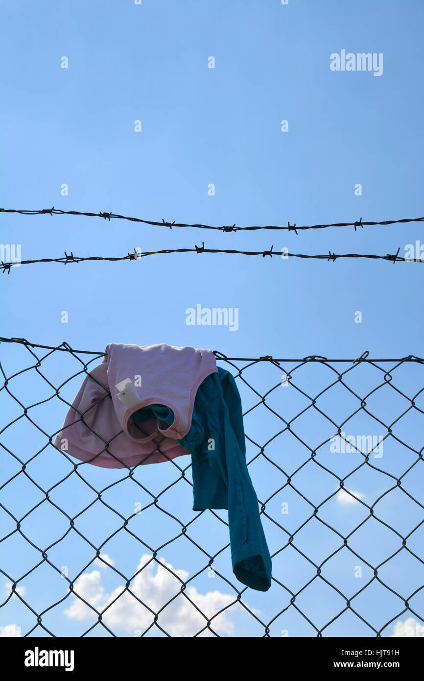 Children clothing hanging on wire mesh fence Stock Photo