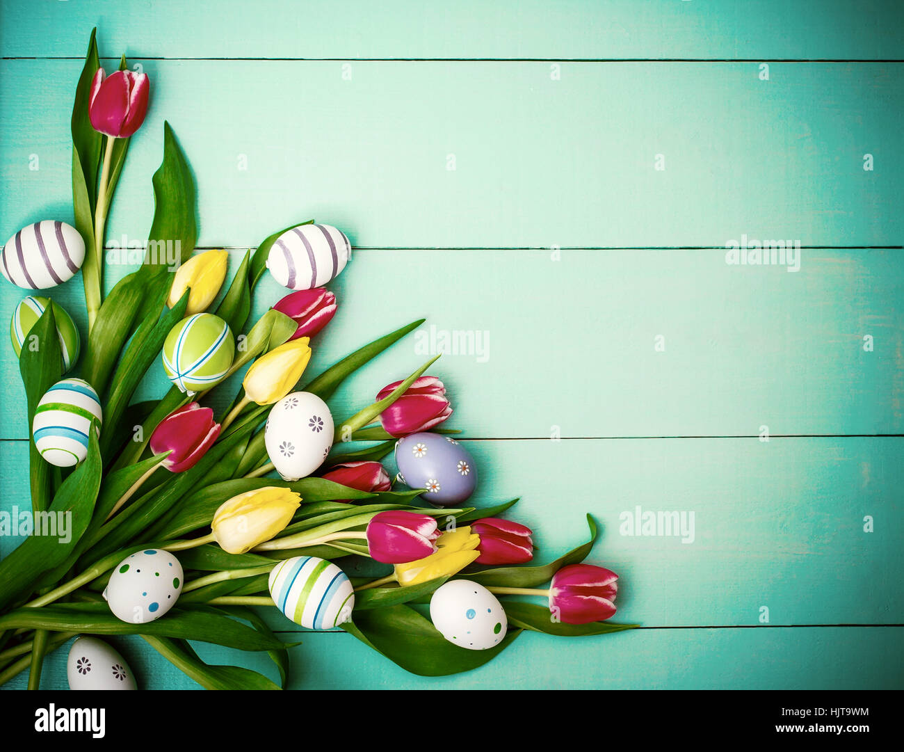 Red and yellow tulips with colorful Easter eggs, top view Stock Photo ...
