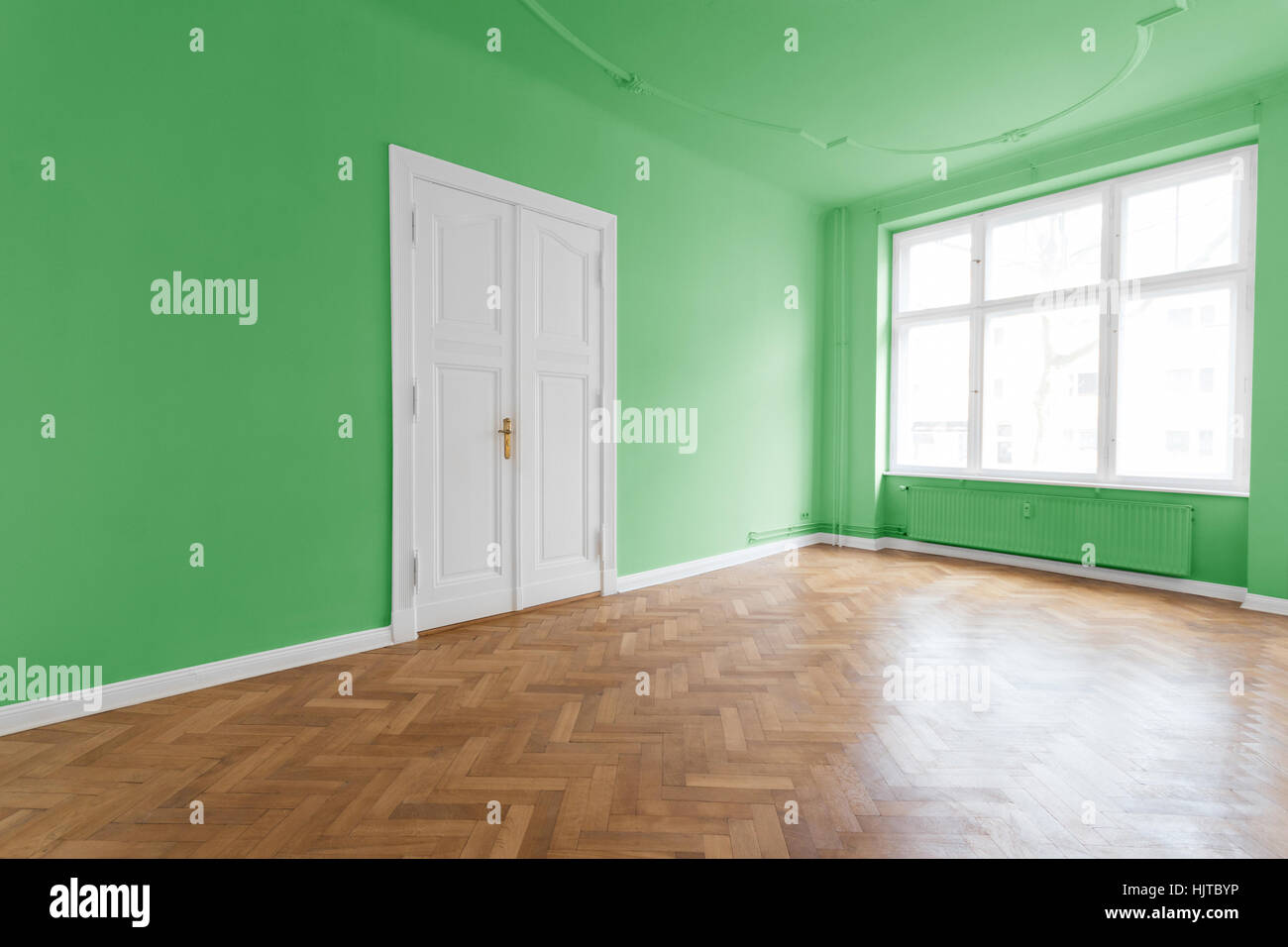 room with green walls and parquet floor Stock Photo
