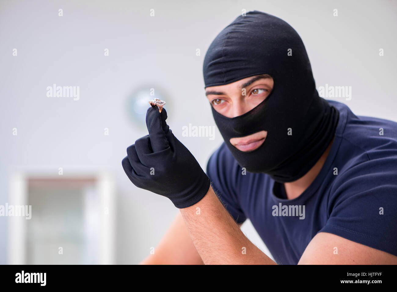Robber wearing balaclava stealing valuable things Stock Photo Alamy