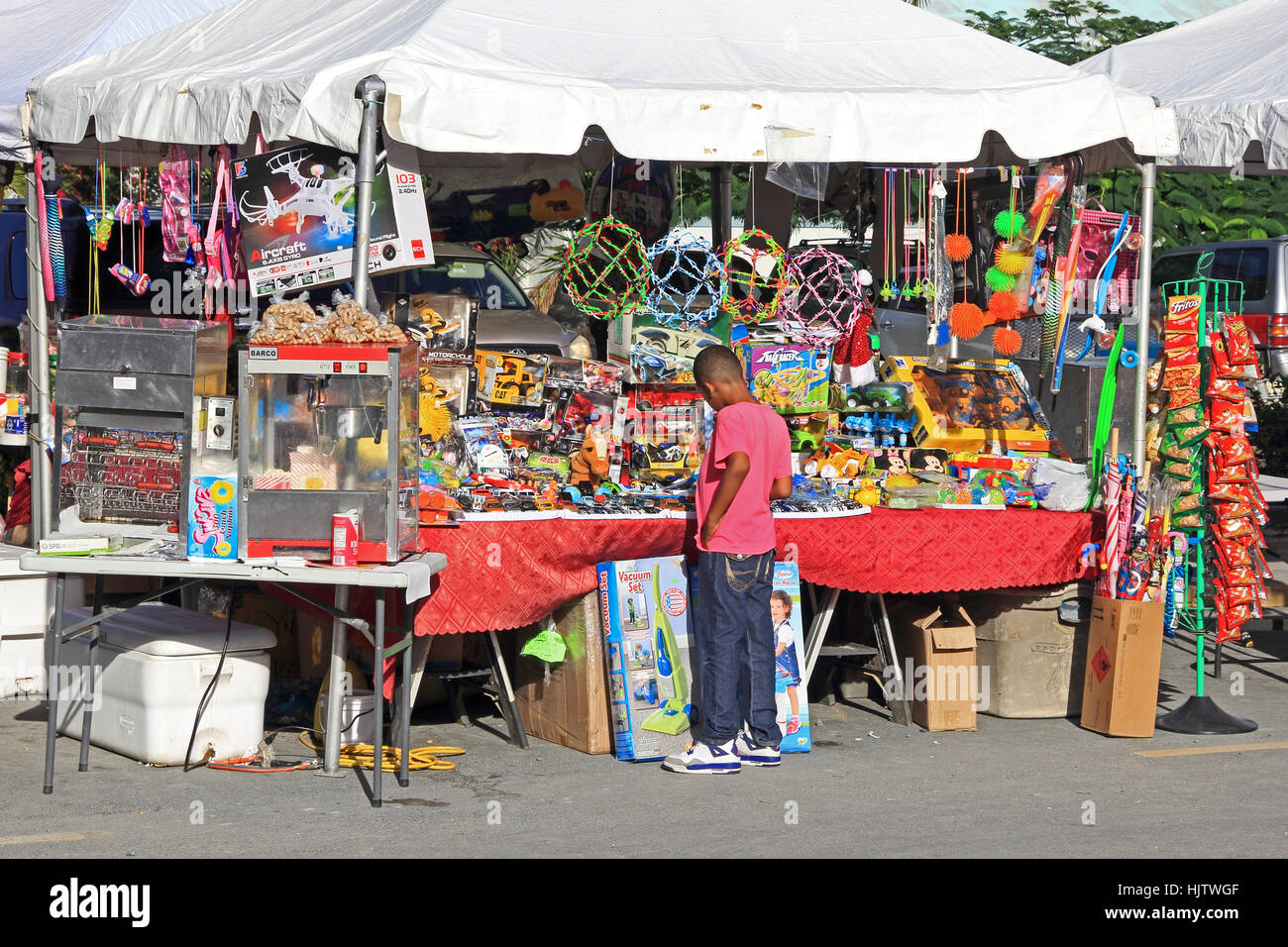 Boy looking at toys on market stall, Road Town, Tortola Stock Photo