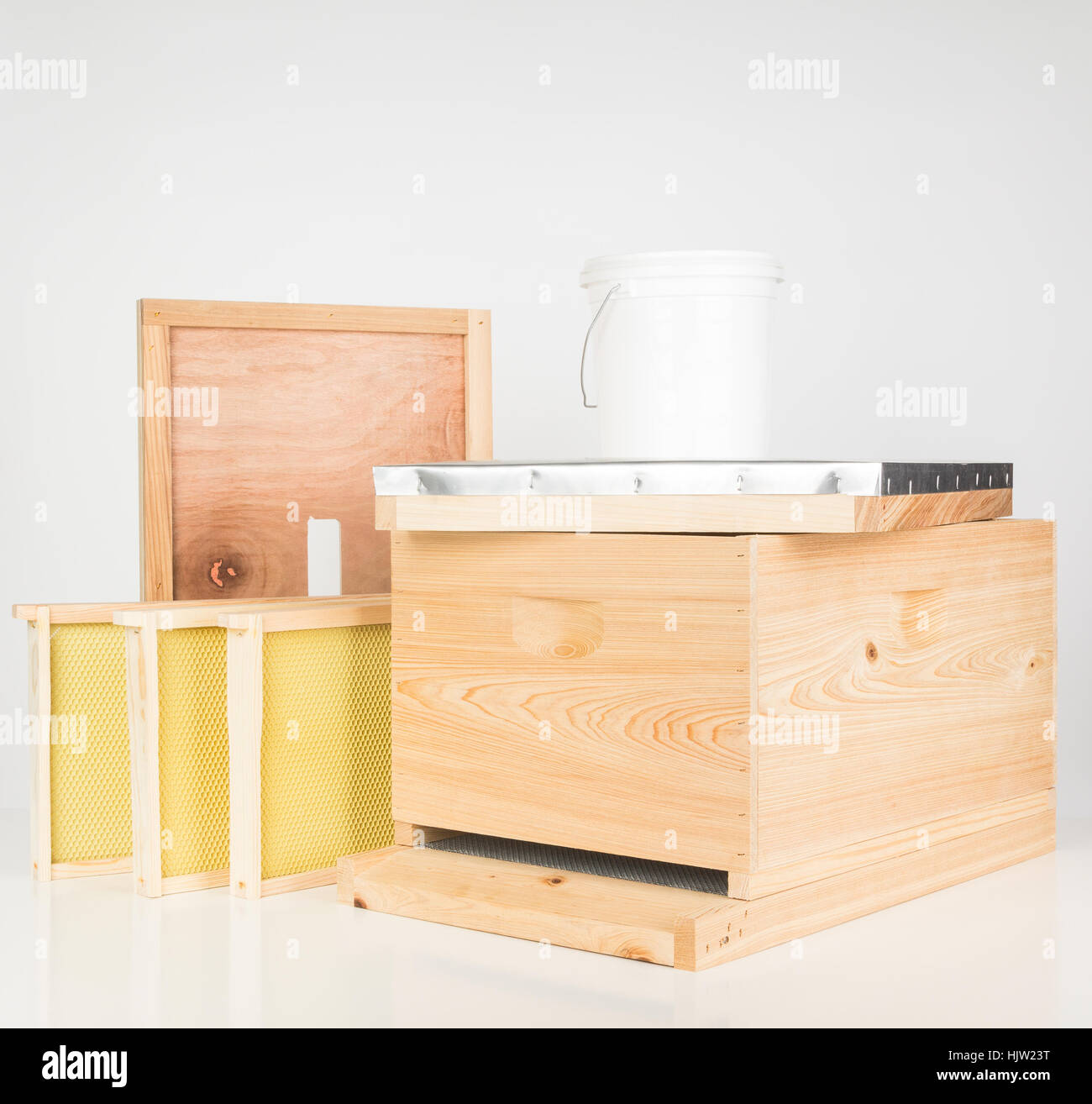New starter kit  cypress wooden honey bee hive, with a few frames and syrup feeding bucket. Stock Photo