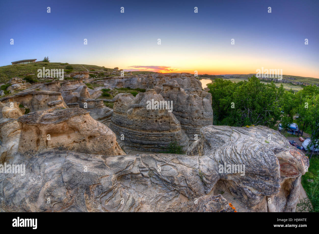 Golden sunrise over the Hoodoo badlands at Writing on Stone Provincial Park and Aisinaipi National Historic Site in Alberta. Stock Photo
