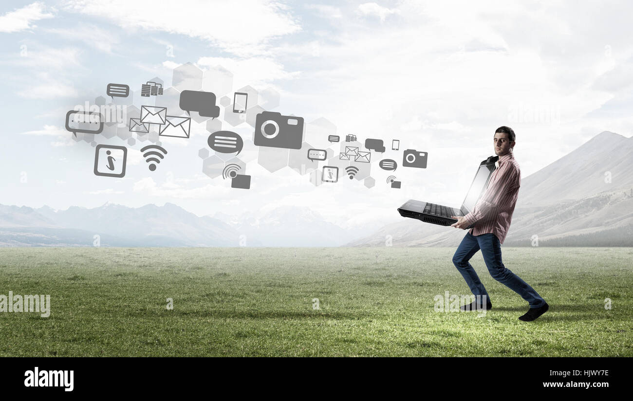 Young man in casual carrying big laptop in hands hi-res stock ...