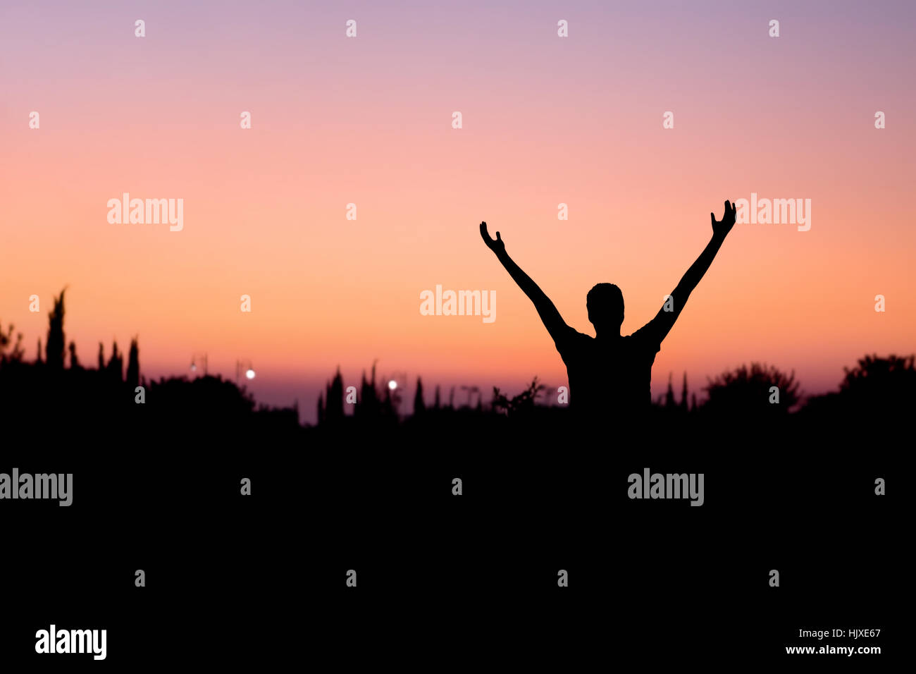 Silhouette of a man with arms raised at night Stock Photo - Alamy