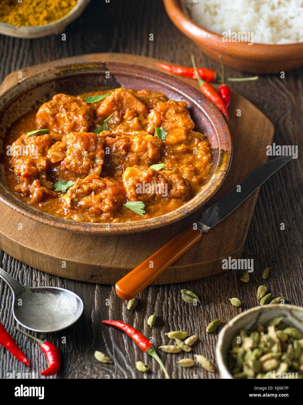 A delicious home made fish curry with chili peppers, cilantro, and basmati rice. Stock Photo