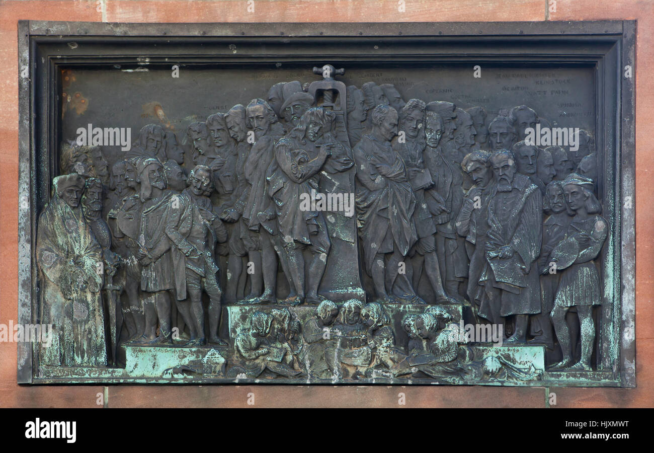 Bronze relief devoted to the benefits of book printing for Europe on the monument to Johannes Gutenberg (1840) by French sculptor David d'Angers in Strasbourg, France. Erasmus, Durer, Voltaire, Descartes next to the printing press, Montesquieu, Leibniz, Alessandro Volta, Galilei and Raphael are depicted (from left to right) in the foreground. Torquato Tasso, Cervantes, Poussin, John Milton, Mozart, Moliere, Pierre Corneille, Shakespeare, Jean-Jacques Rousseau, Lessing, Immanuel Kant, Copernicus, Goethe, Friedrich Schiller, Hegel, Isaac Newton and Spinoza appear among the other in background Stock Photo