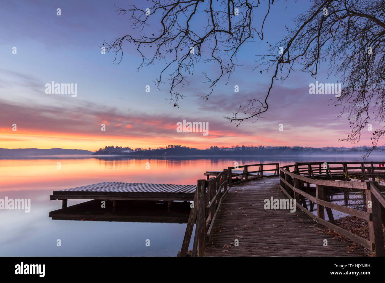 Winter sunrise on the Gavirate pier of Lago di Varese, Varese Province, Lombardy, Italy. Stock Photo