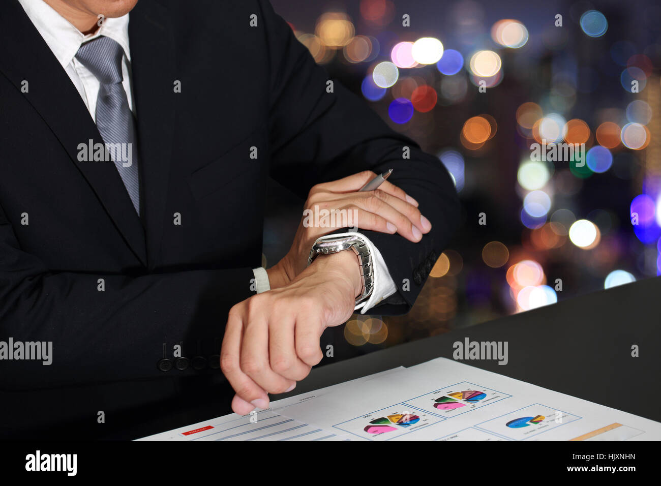 Business man look at time on blurred abstract bokeh background as Appointment Concept. Stock Photo