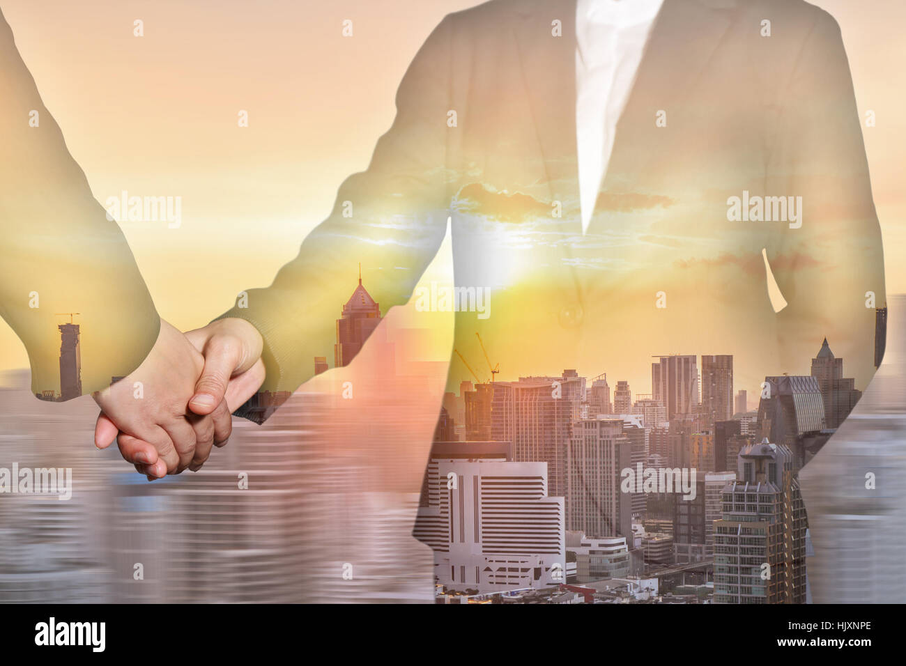 Double exposure of business women handshake , city and sunset on motion background as Partnership concept. Stock Photo