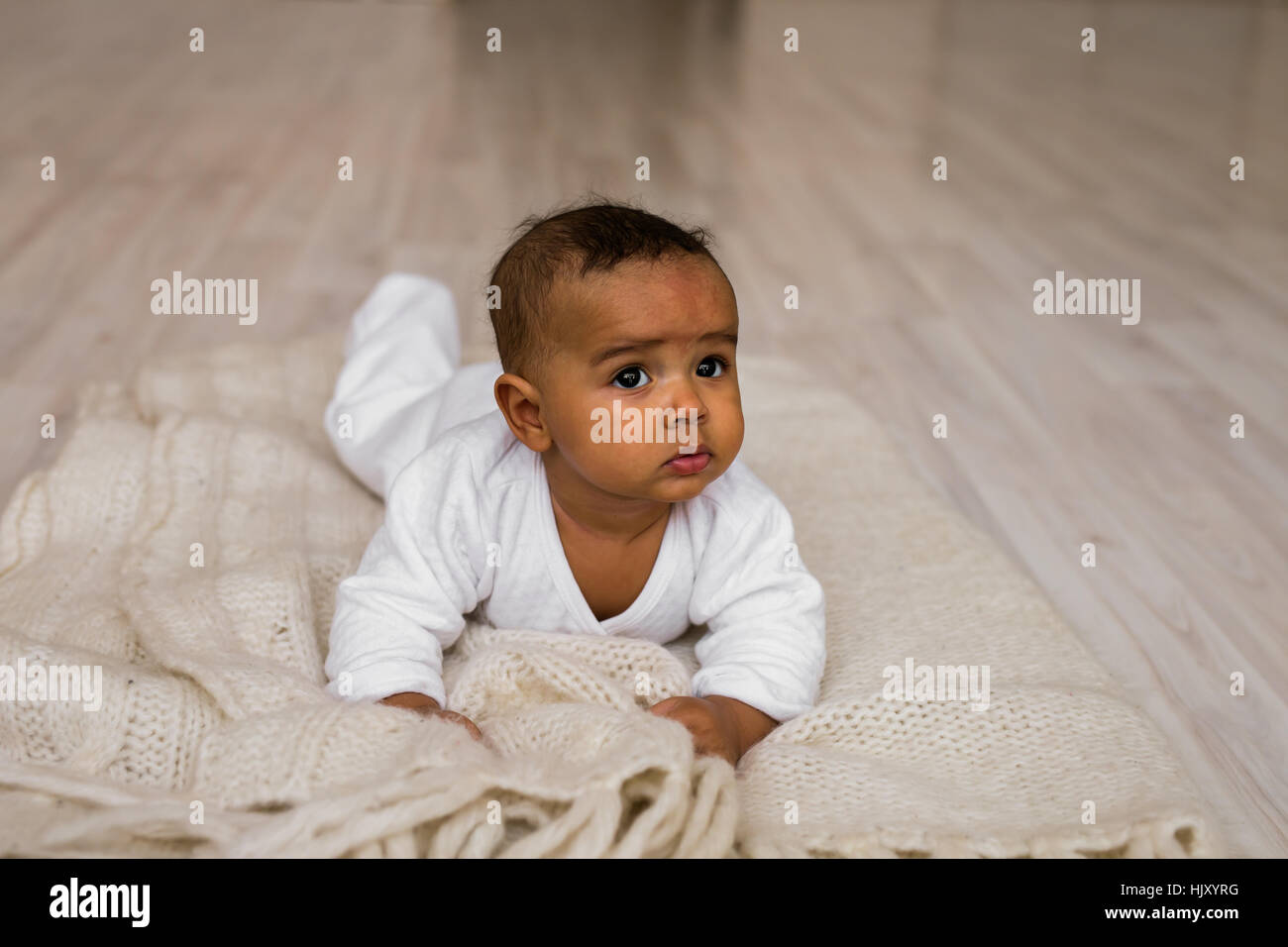 Cute Mixed Race African American Baby Boy Plays On Bed Stock Photo