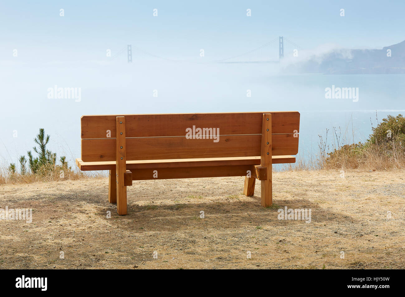 Park Bench On Angel Island Over Looking The Fog Covered San Francisco Bay And The Golden Gate Bridge. Stock Photo