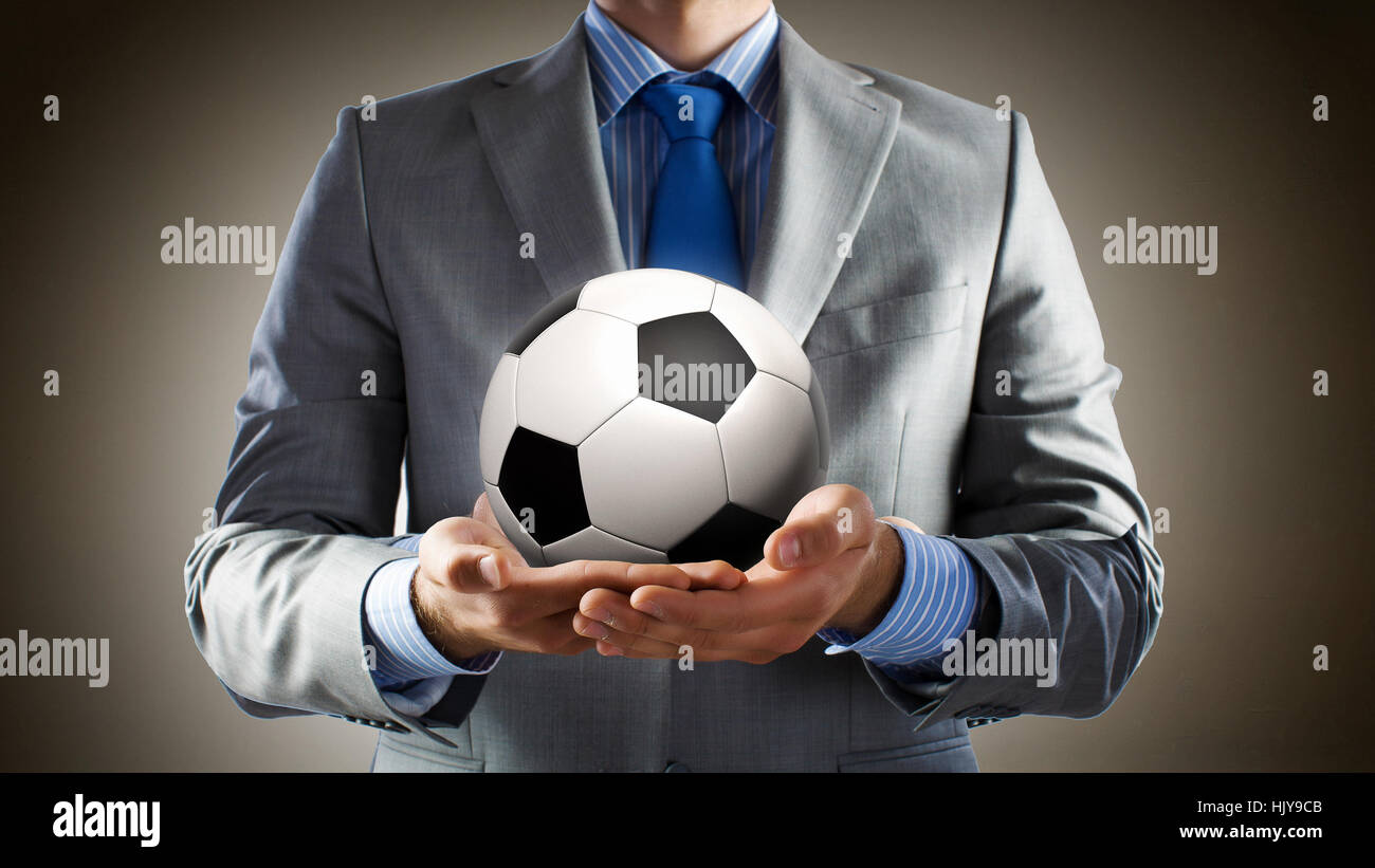 Close up of businessman holding soccer ball in hand Stock Photo - Alamy