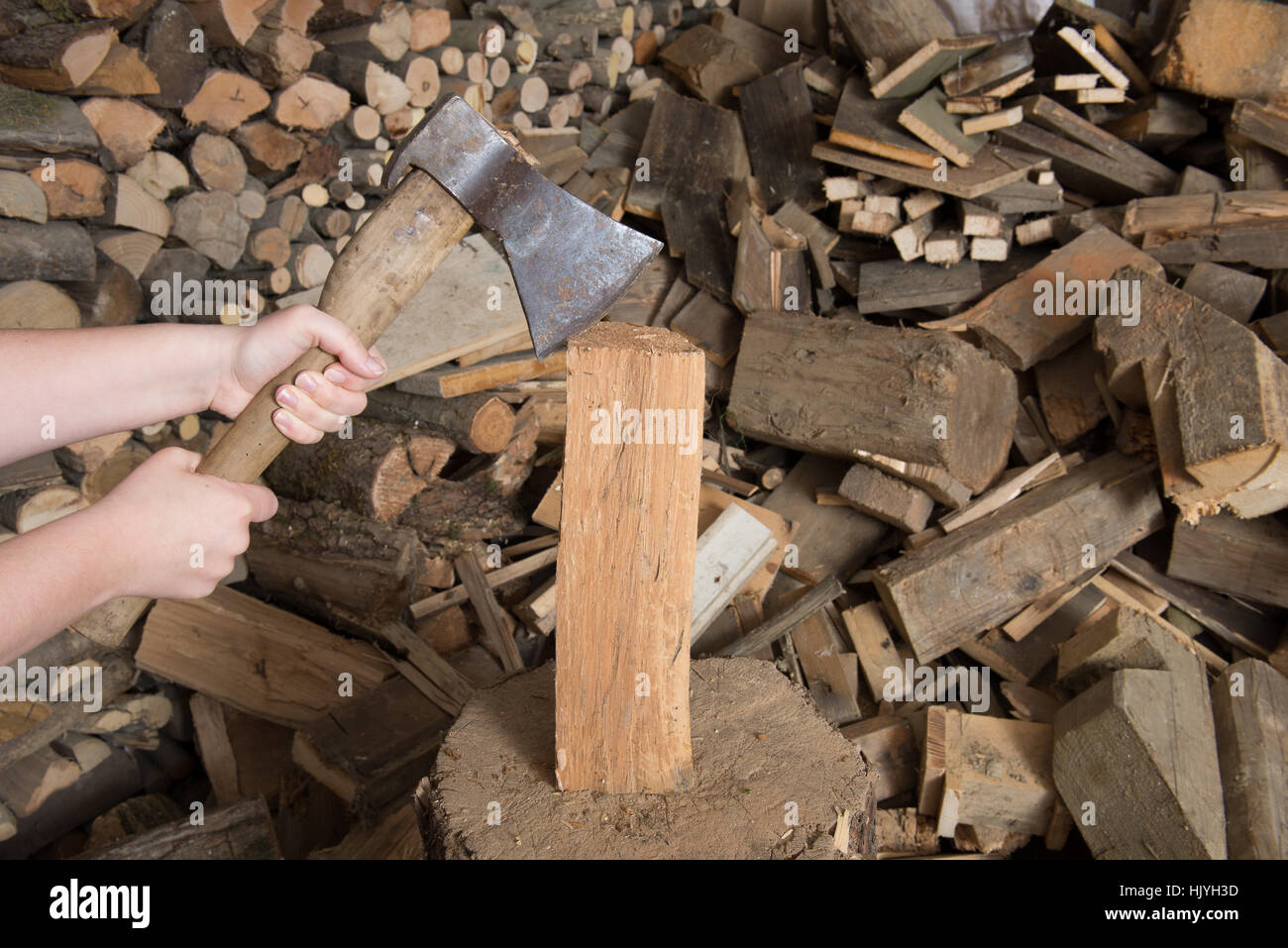 chop wood with ax on chopping block with funeral in the background Stock Photo
