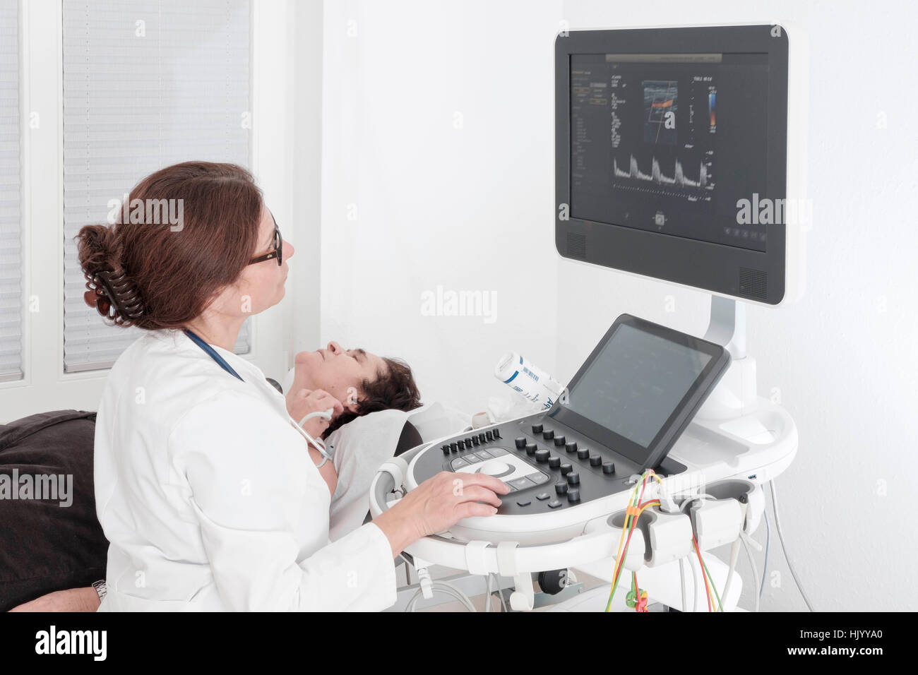 Cardiologist performing echocardiogram on senior female patient Stock Photo