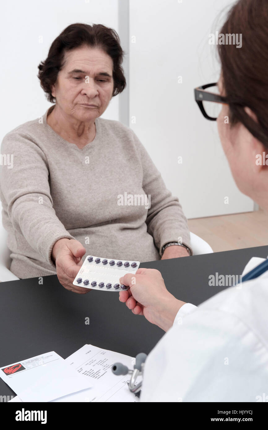 Doctor prescribing medication to senior female patient-selective focus Stock Photo