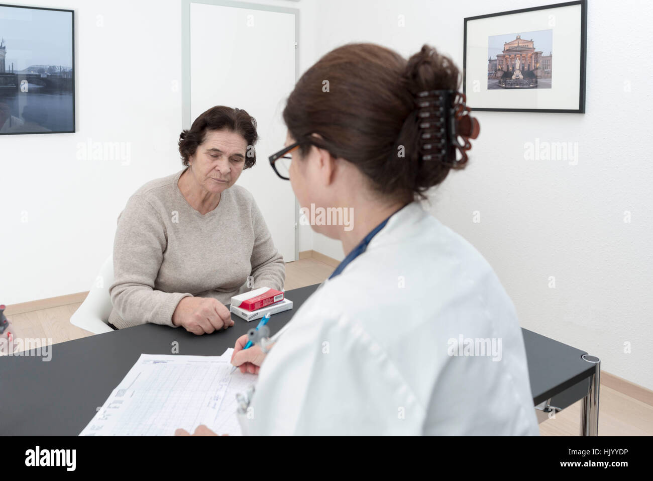 Doctor prescribes medication to senior female patient. Medical check up Stock Photo